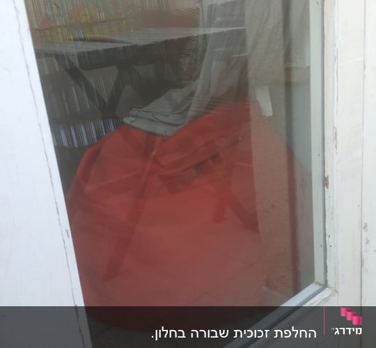 חלון זכוכית עם השתקפות של פנים החדר